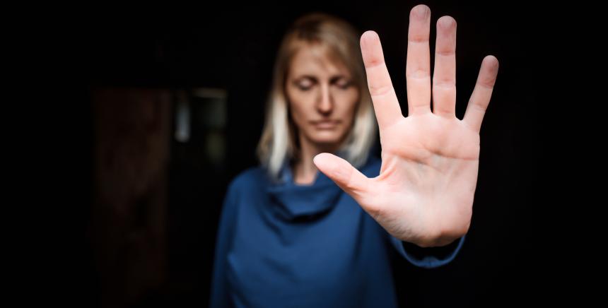 Image d'une femme qui réalise le signe stop avec sa main